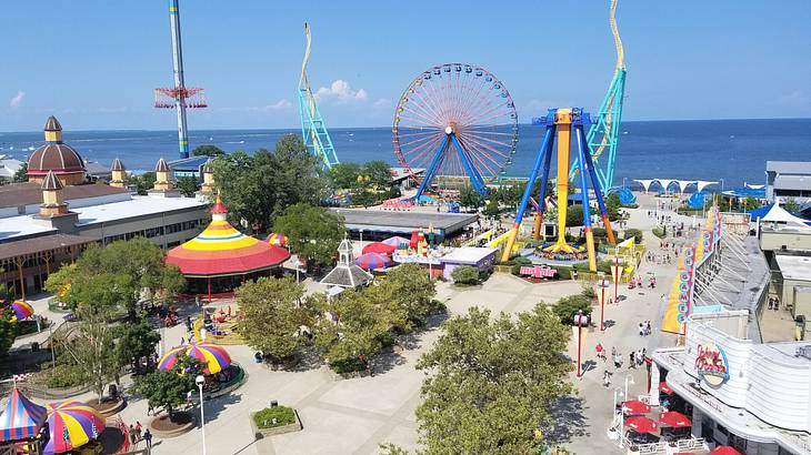 A view over a colorful amusement park next to the water on a clear day