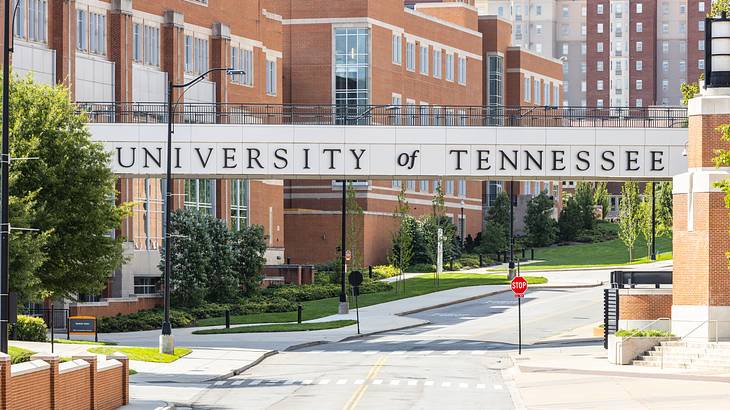 Bridge with "University of Tennessee" sign over a street against red brick buildings