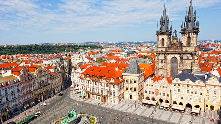 An old square surrounded by buildings, a cathedral and people from above