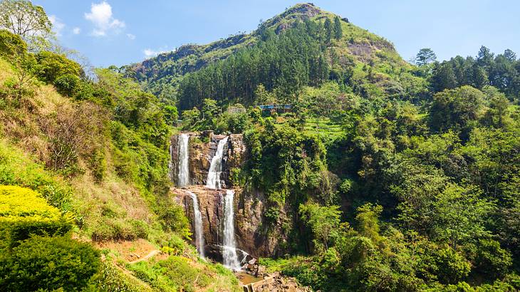 Set of twin waterfalls falling down cliffs amongst lush greenery