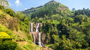 Set of twin waterfalls falling down cliffs amongst lush greenery