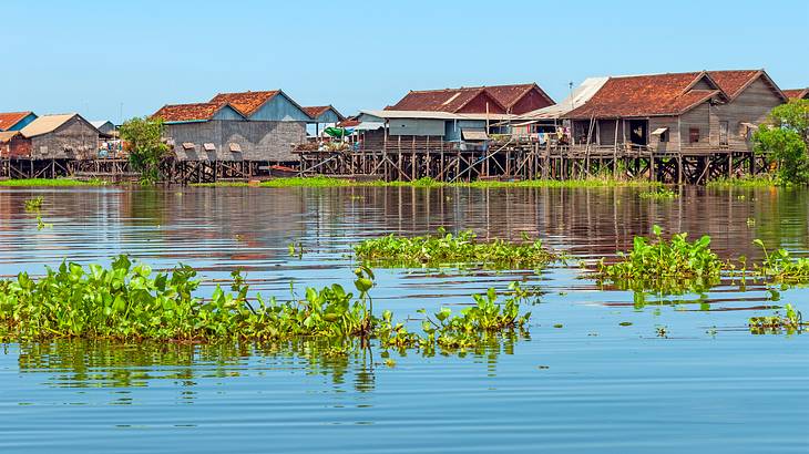 Houses on stilts in a floating village against a blue sky