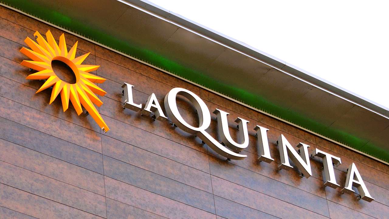 A vertical surface covered in wood-like tiles with a sign saying "La Quinta"