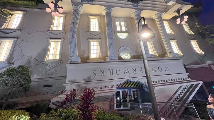 An upside-down building with columns, lit windows, and an entrance in the front An upside-down building with columns, lit windows, and an entrance in the front