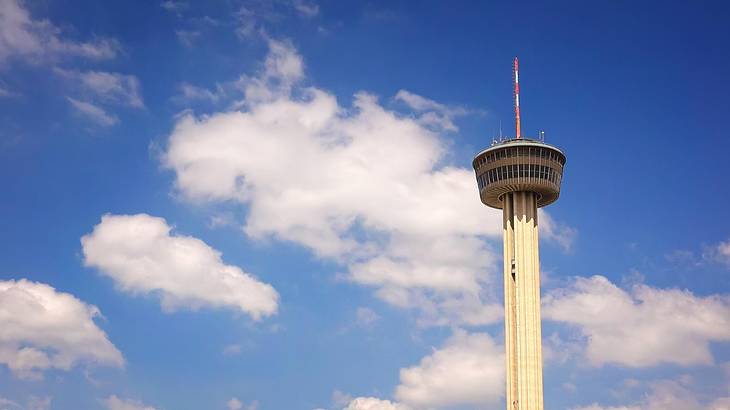 An observation tower with a blue sky with clouds