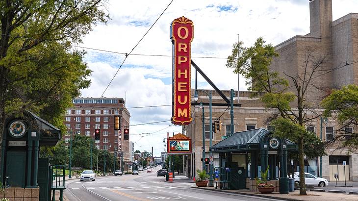 A large red and orange sign that says "Orpheum" on a brick building next to a street A large red and orange sign that says "Orpheum" on a brick building next to a street