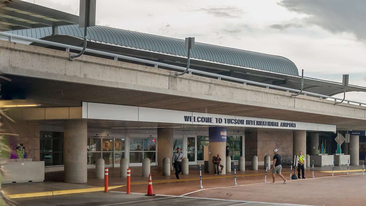 An entrance to an airport with a "Tucson International Airport" sign