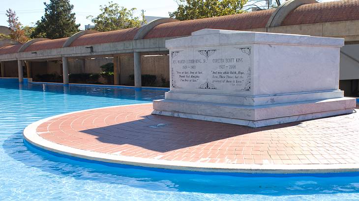 tombstones over a bricked area with a pool in front