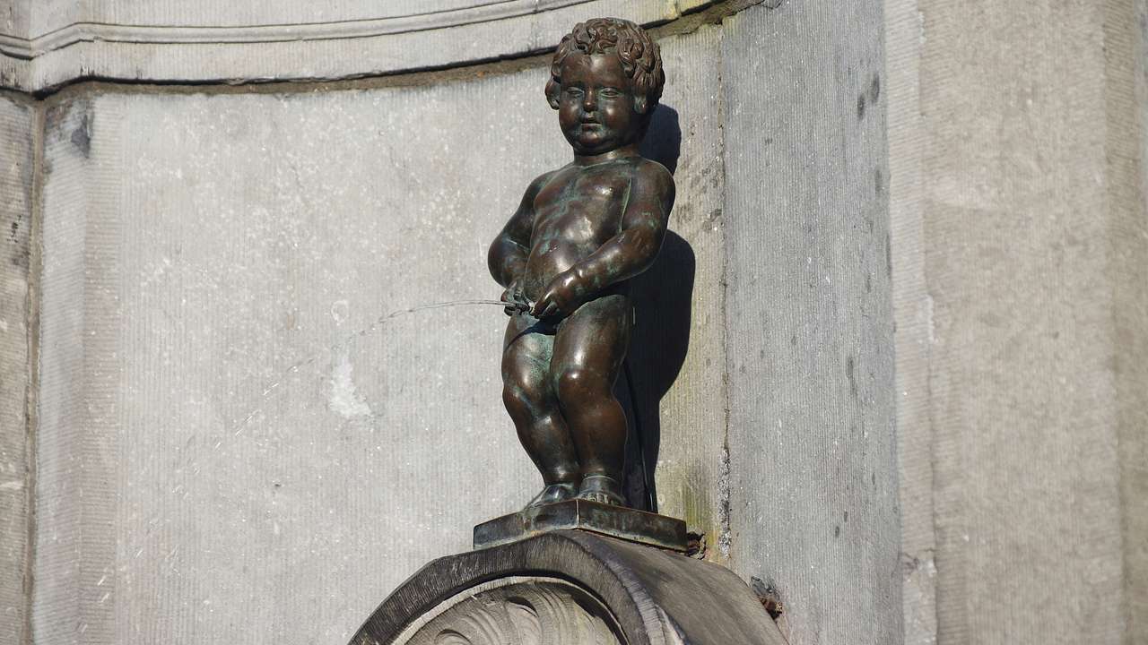 A bronze statue fountain depicting a little boy urinating