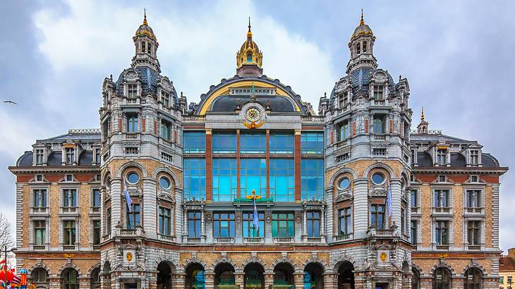 A large building made of stone with many windows and three small domes atop it