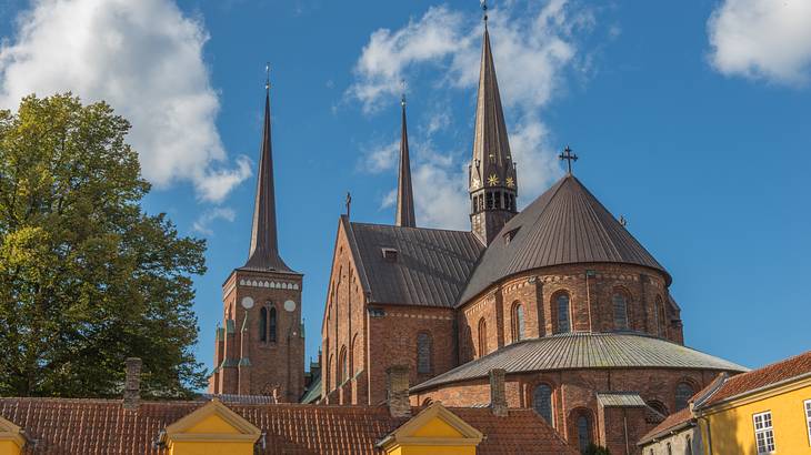 A gothic-style brick building with spires next to a blue sky