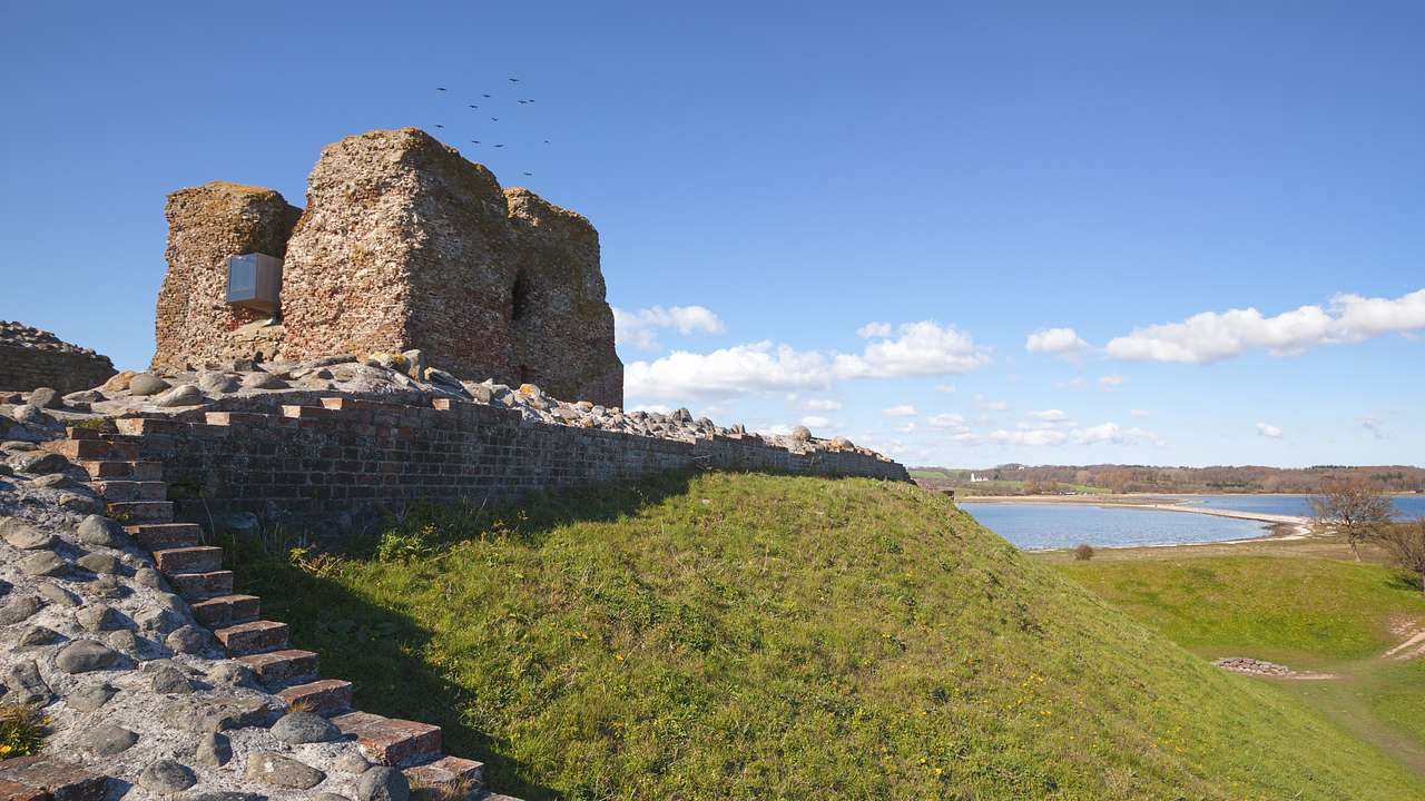 Ruins of a castle atop a small hill with stairs leading to it