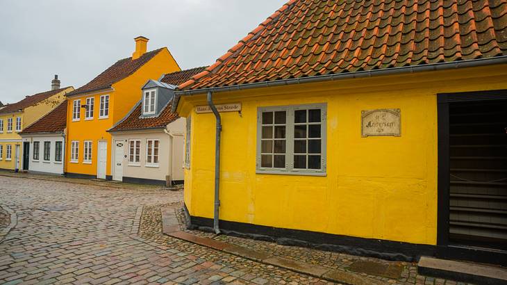 Small yellow and cream houses next to a brick path