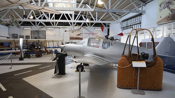 The interior of a museum with airplanes and exhibit plaques
