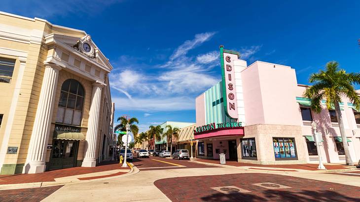 A street with retro buildings and palm trees under a blue sky