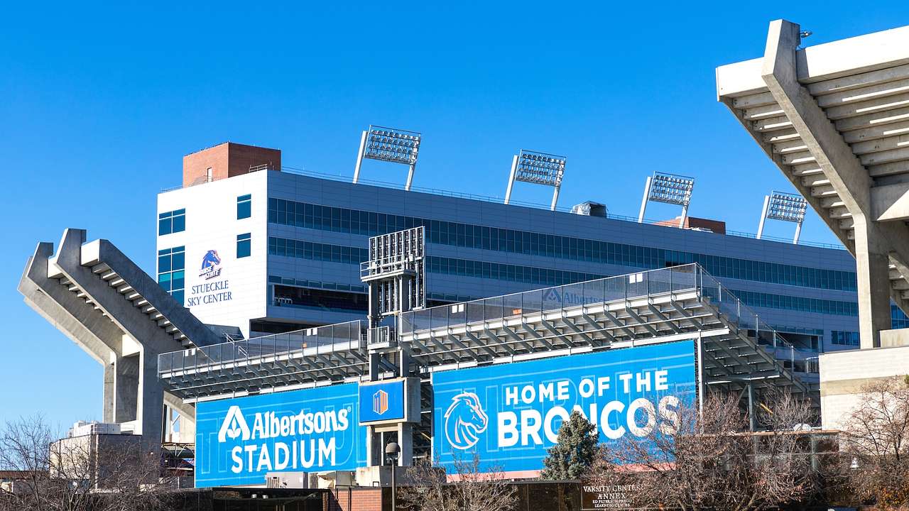 A stadium with blue signs saying "Albertsons Stadium" and "Home of the Broncos"