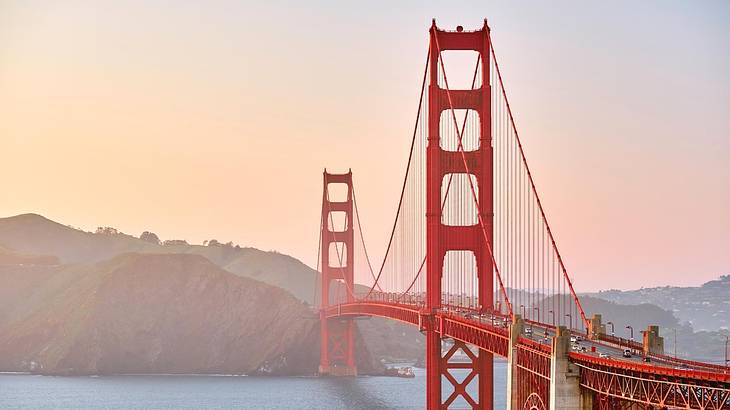 A red suspension bridge at covered by a light fog