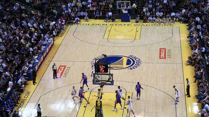 A basketball court with a game being played and fans watching