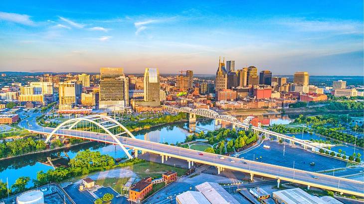 An aerial view of a city with a bridge over a river and many skyscrapers