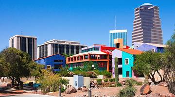 Unique colorful buildings next to taller buildings and green plants