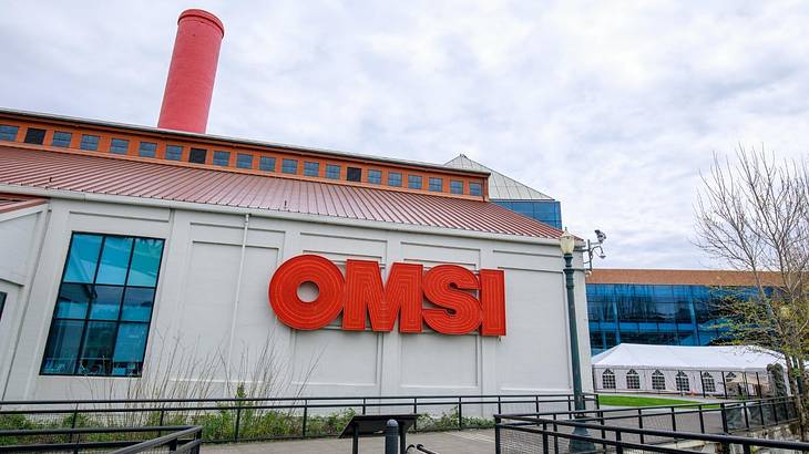 A white building with a big red sign of "OMSI" and a red roof