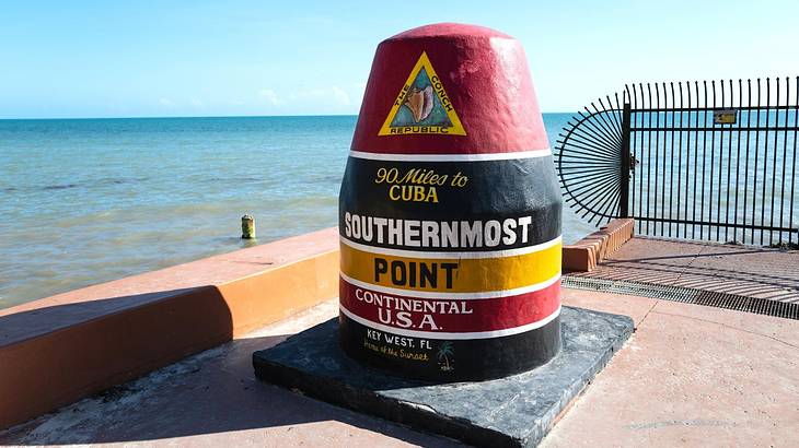 A marker for the Southernmost Point of the US and the ocean in the background