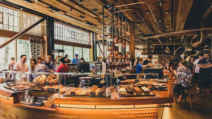A luxury coffee shop with baked goods on display and people ordering A luxury coffee shop with baked goods on display and people ordering