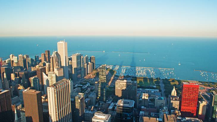 A view of a city as seen from above with skyscrapers and water in the background