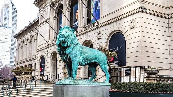 A lion statue outside of a stone museum building A lion statue outside of a stone museum building