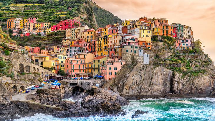 Colourful houses standing on steep terraces of a village with the sea below
