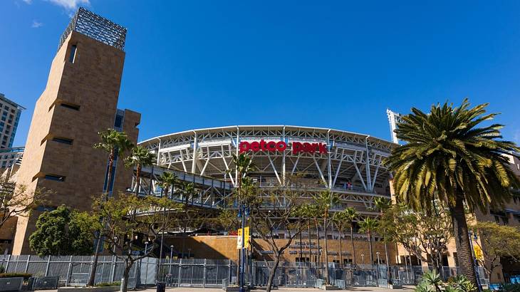 A sports stadium with a "Petco Park" sign and palm trees in front of it