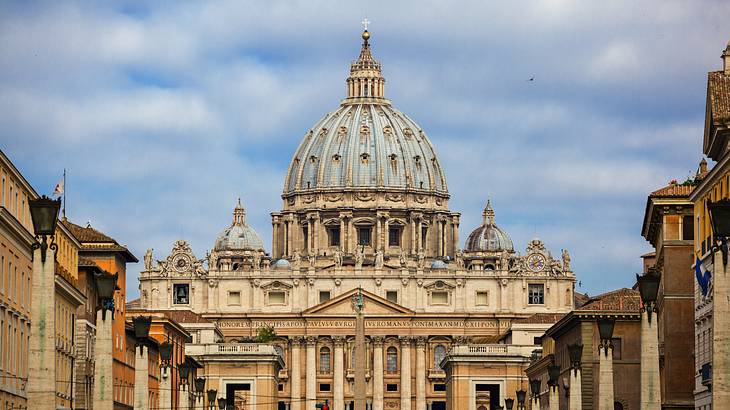 St. Peter's Basilica's exterior and dome against a partly cloudy sky