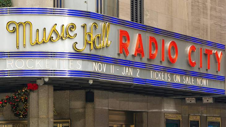 A building with a yellow and red "Radio City Music Hall" sign on it