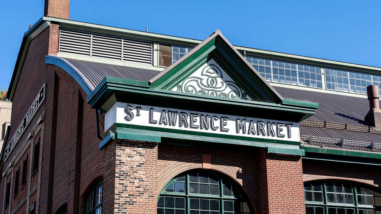 A sign on a red brick building that says "St Lawrence Market"