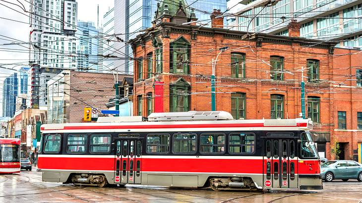 A red city tram on Queen Street West in Toronto, Ontario, Canada