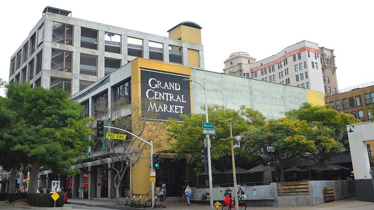 A building with a yellow wall and a sign that says "Grand Central Market"