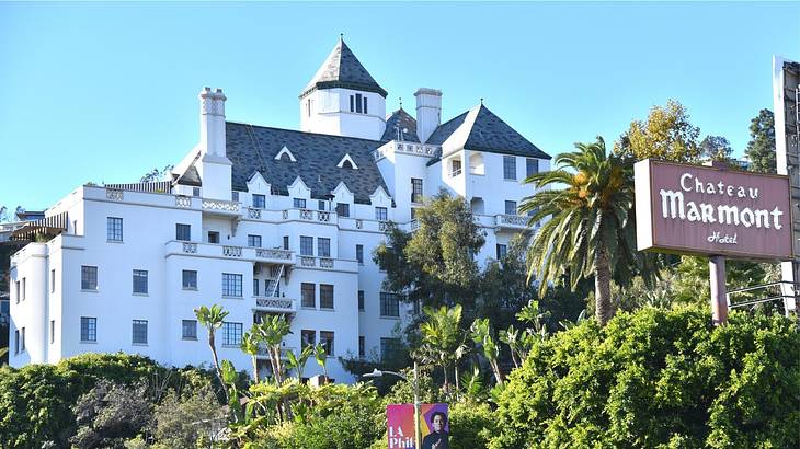 A mansion building with greenery and a "Chateau Marmont" sign in front of it