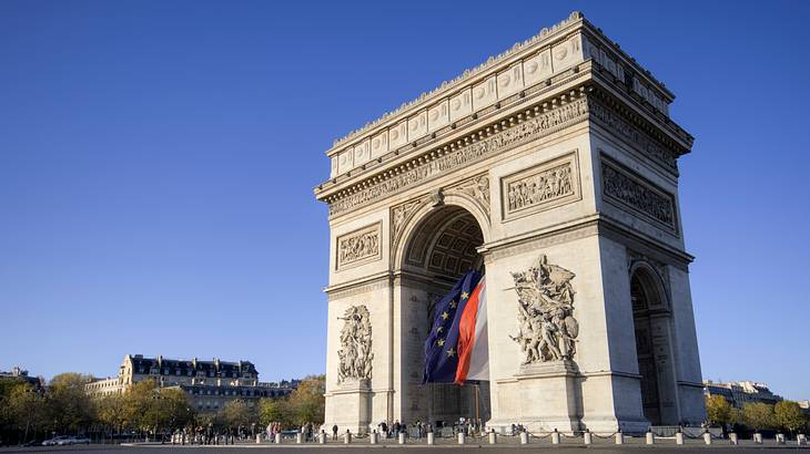 Arc de Triomphe on a fine day, standing tall against a clear blue sky