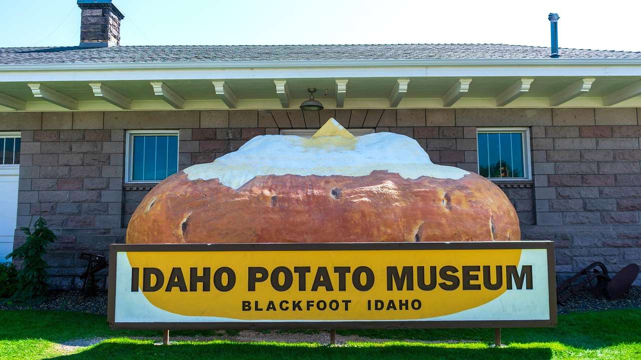 Looking at a "Idaho Potato Museum" sign, with a potato against a brick house