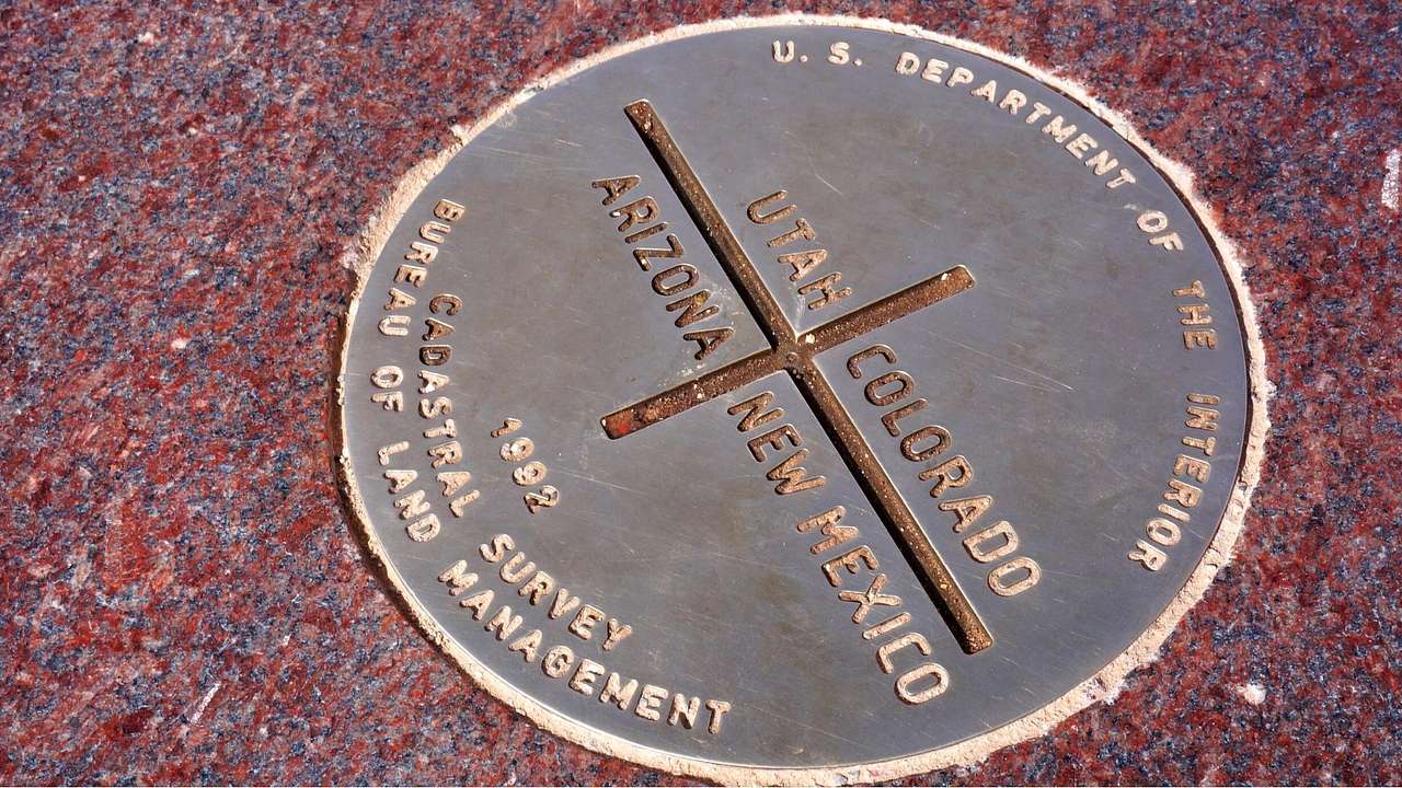 A round monument with the text of Arizona, New Mexico, Utah, and Colorado