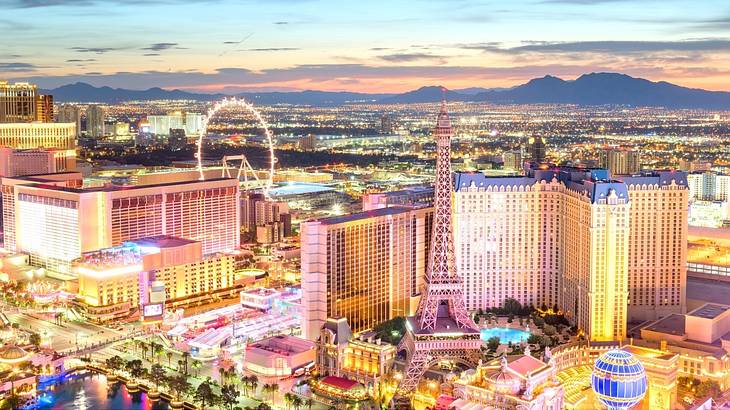 A view of Las Vegas at sunset with tall buildings and an Eiffel Tower replica