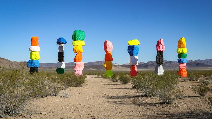 Seven towers of different colored boulders standing in the desert
