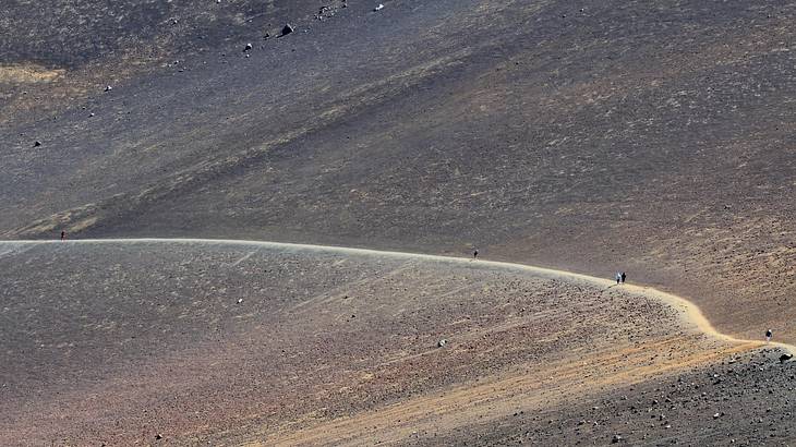 People hiking a volcanic crater and mountain, Keonehe’ehe’e Trail, Maui, Hawaii, USA People hiking a volcanic crater and mountain, Keonehe’ehe’e Trail, Maui, Hawaii, USA
