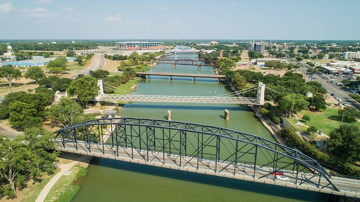 Bridges stretching over green waters with land and trees on either side