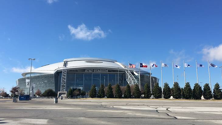 A football stadium with flags next to it and concrete in front of it