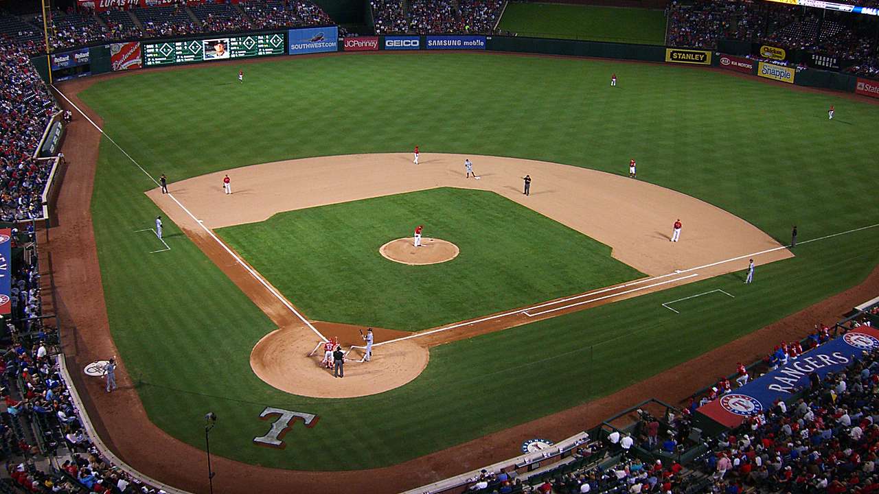 A baseball field with a game going on and people watching from the stands