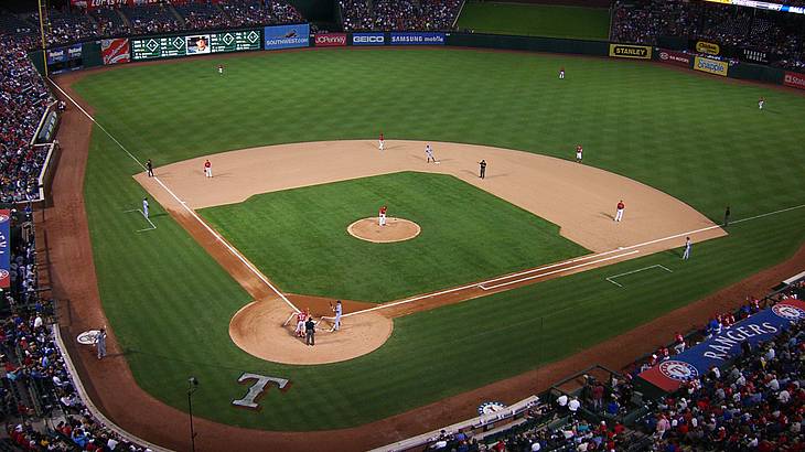 A baseball field with a game going on and people watching from the stands