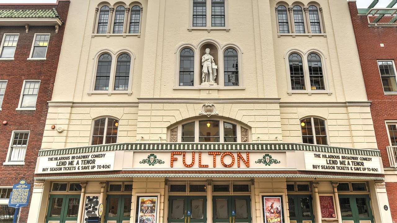 The exterior of a stone theater building with a sign that says "Fulton"