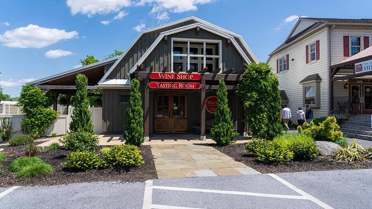 A wooden barn-type shop with a sign that says "wine shop tasting room"