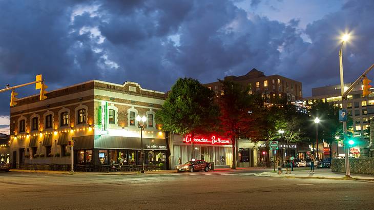 A street at night with illuminated bars and restaurants on one side